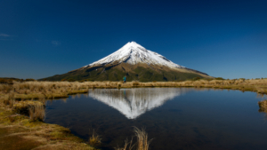 Mount Taranaki reflected in the water scenic view snowcapped mountains against clear blue sky - The Ultimate Expedition to Cotopaxi Volcano: A Journey to the Peak of the Andes - Columbus Travel Ecuador